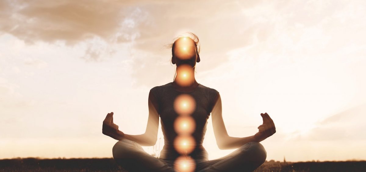 Woman meditating with chakras marked