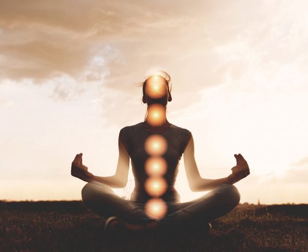 Woman meditating with chakras marked