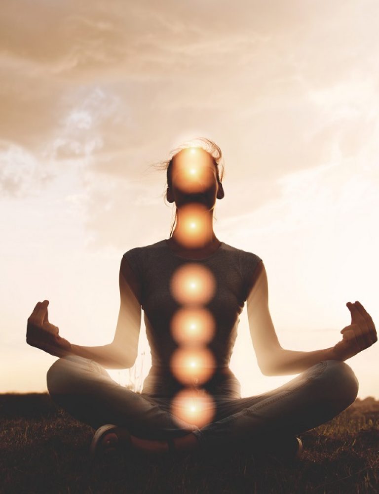 Woman meditating with chakras marked